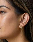 Close-up of a woman wearing gold earrings with a blurred background