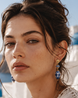 Woman with floral dress and earrings in a scenic location