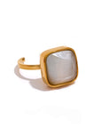 Gold ring with a square stone on a white background