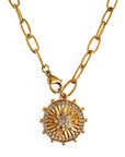 Gold necklace with a circular pendant on a white background