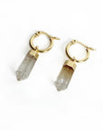 Gold hoop earrings with crystal-like pendants on a white background