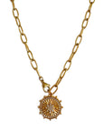 Gold necklace with a circular pendant on a white background