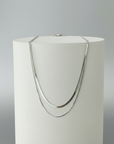 A silver plated double layer chain necklace displayed on a mannequin.