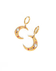 Gold letter 'S' earrings with colorful stones on a white background