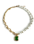 Necklace with gold chain, green gemstone pendant, and pearl accents on a white background