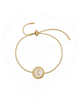 Gold bracelet with a moon symbol on a white background