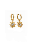 Gold hoop earrings with star-like designs on a white background