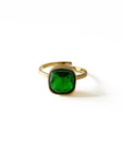 Gold ring with a green gemstone on a white background