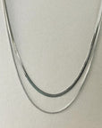 A silver plated double layer chain necklace displayed on a mannequin.