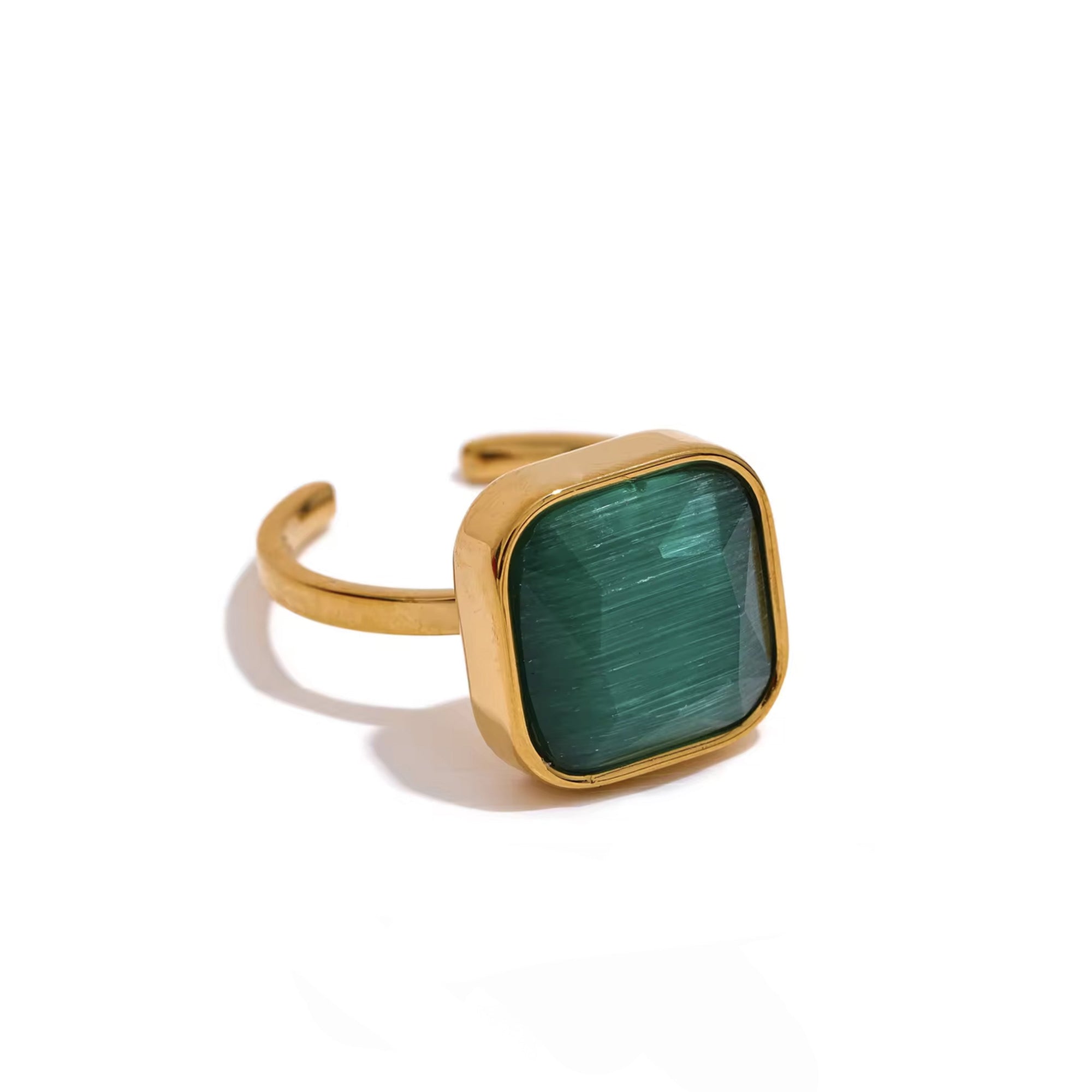Gold ring with a green square stone on a white background