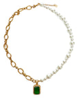 Necklace with gold chain, green gemstone pendant, and pearl strand on a white background