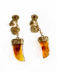 Pair of earrings with amber-colored gemstones and gold accents on a white background