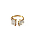 Gold ring with two clear gemstones on a white background