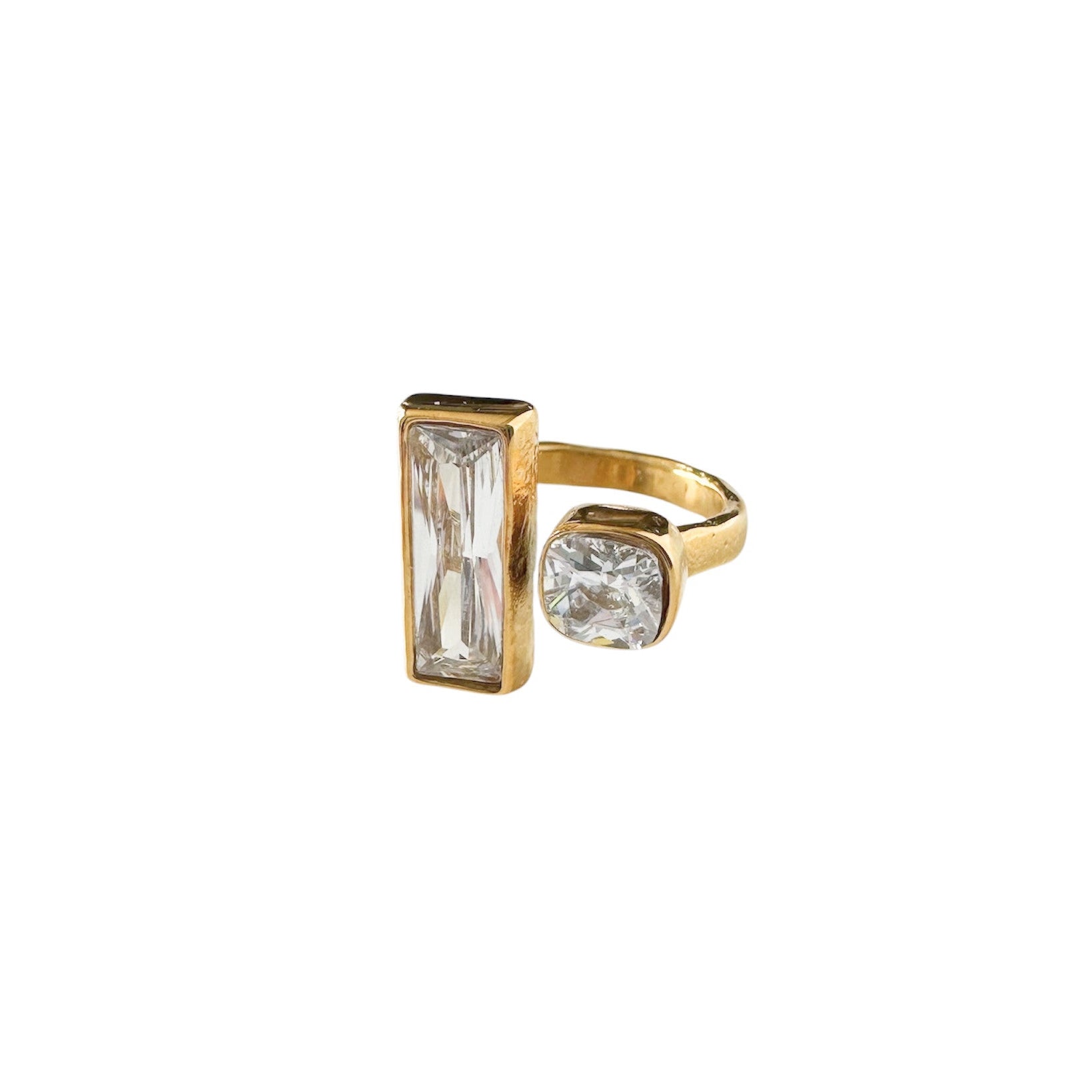 Gold ring with rectangular and round gemstones on a white background