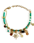 Multicolored beaded bracelet with gold chain and various charms on a white background