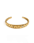 Gold bracelet with star and moon designs on a white background