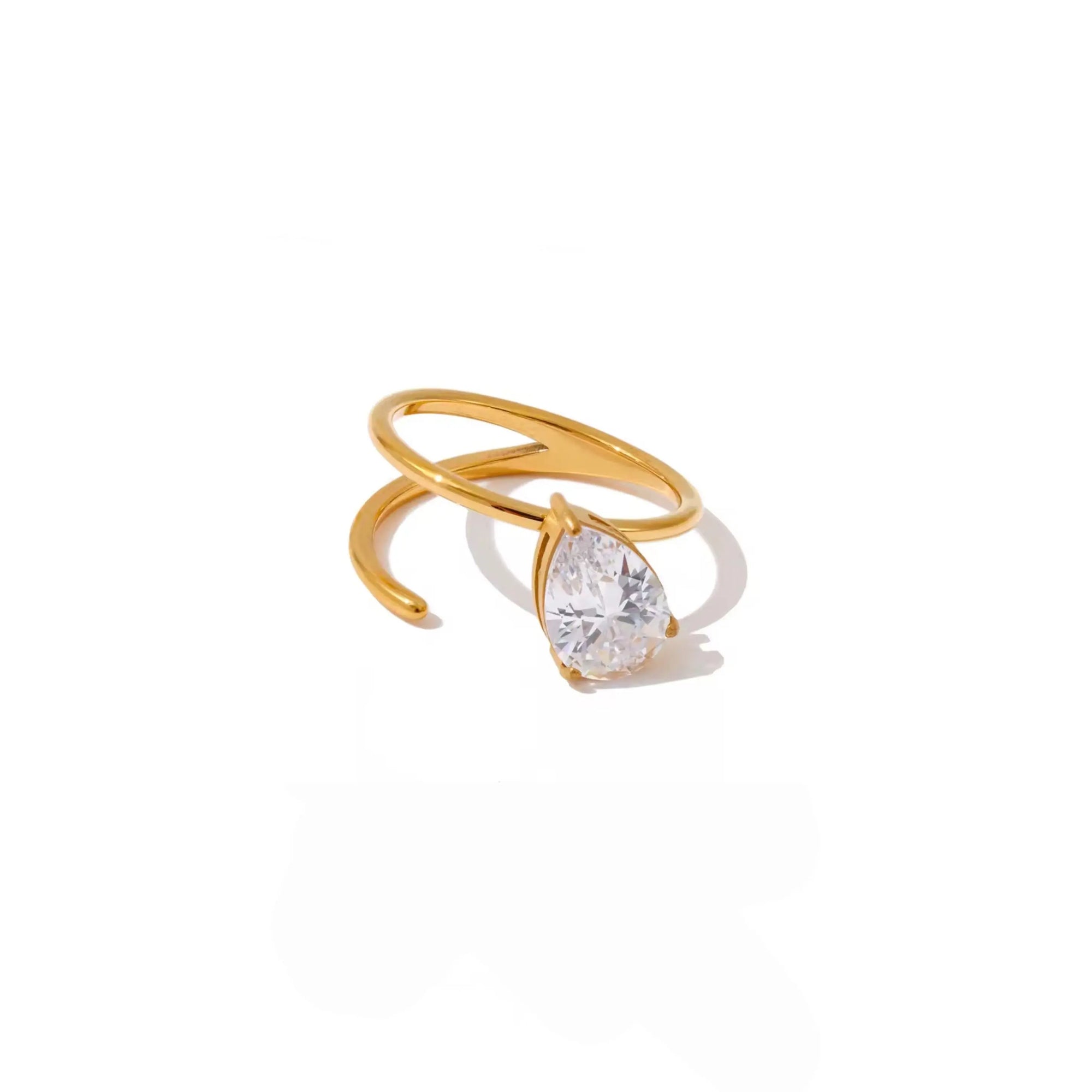 A gold wrap ring featuring a pear-cut clear gemstone in a prong setting, displayed on a clean white background with a soft shadow.