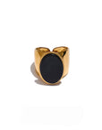 Gold ring with a black stone on a white background