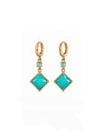 Pair of gold earrings with turquoise gemstones on a white background